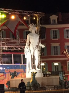 A statue of Apollo in a fountain surrounded by horses. It is not running now while the carnivale celebration is going on.